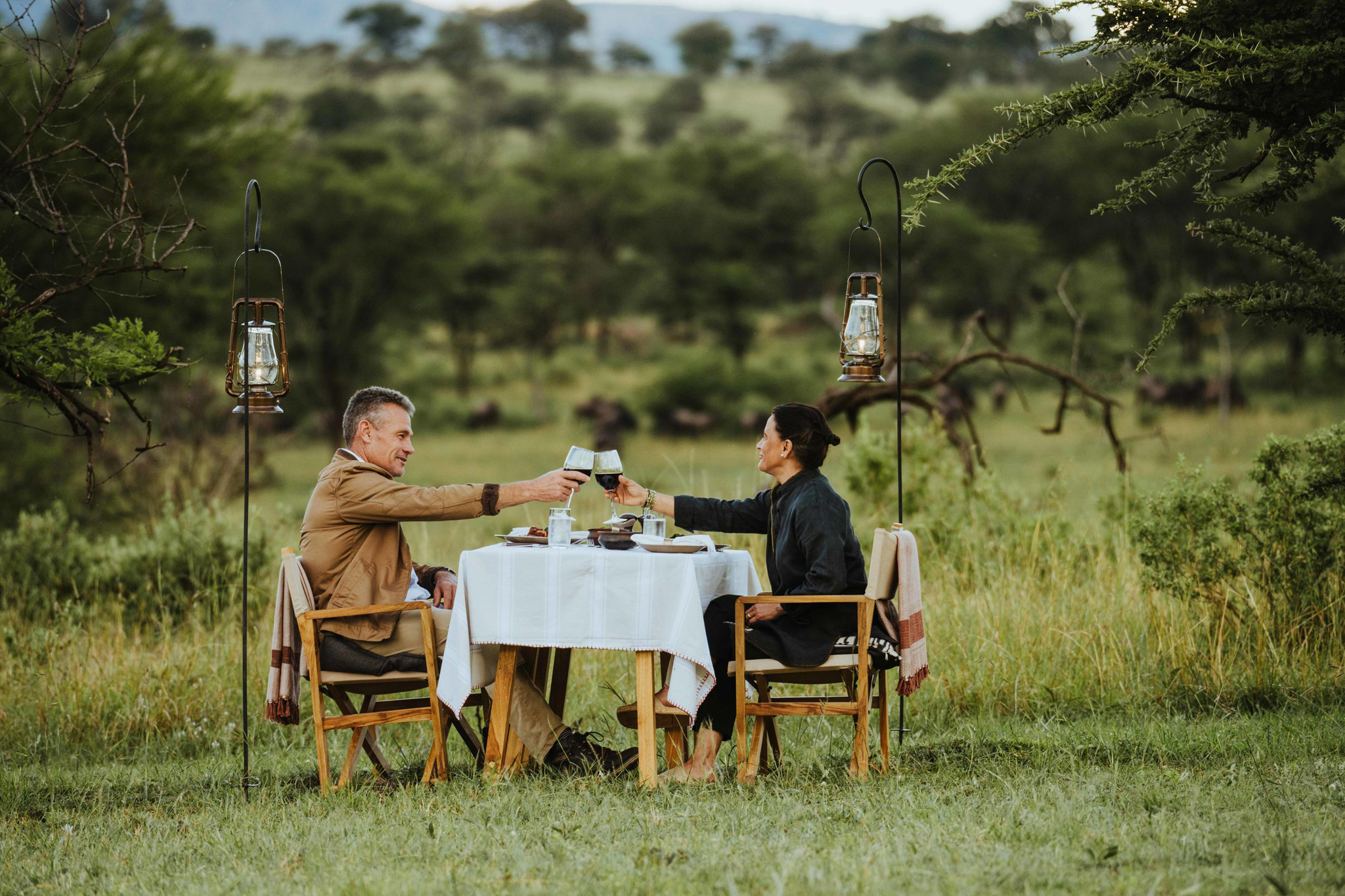 bush dinner setting for couple outside Wilderness Usawa tented camp Serengeti